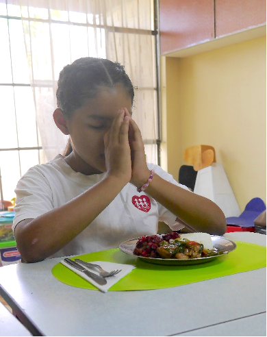 Daniela praying before eating lunch