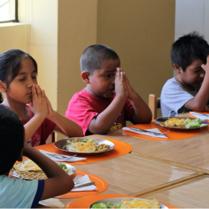 Jacky and her friends praying before lunch at Operación San Andrés